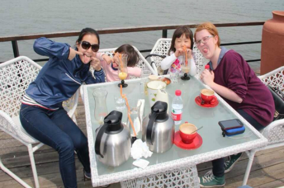 Two GeoVisions au pairs in China with their host sisters having lunch.