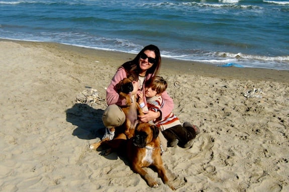 An au pair on the beach in Italy with her host brother and their dog.